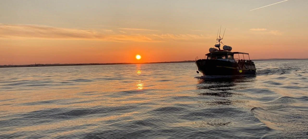 boat sailing with sunset in the background