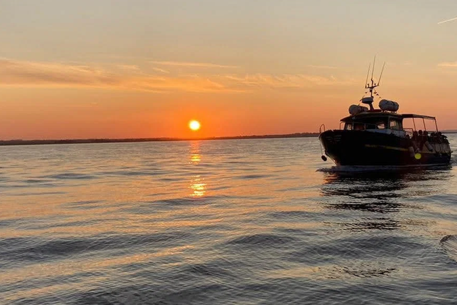 boat sailing with sunset in the background